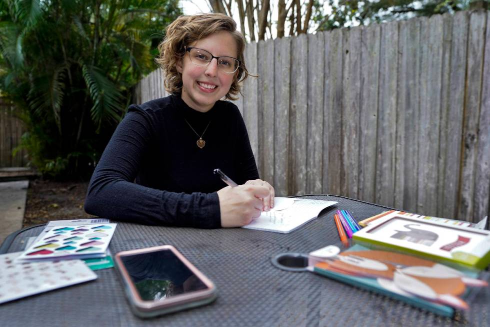 Kara McKlemurry poses for a photo while writing Thanksgiving notes to family and friends at her ...