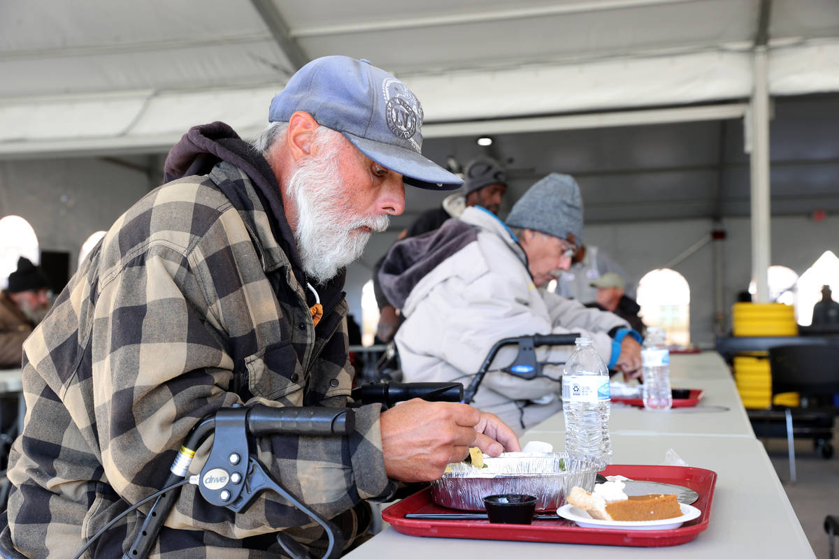 Clients, including Michael Burr, 59, left, eat a socially distanced Thanksgiving meal at the ne ...