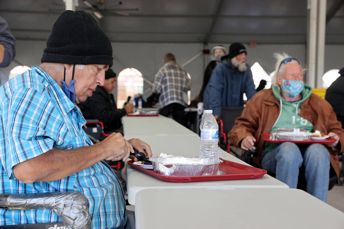 Clients, including Agha Iqbal, 68, left, eat a socially distanced Thanksgiving meal at the new ...