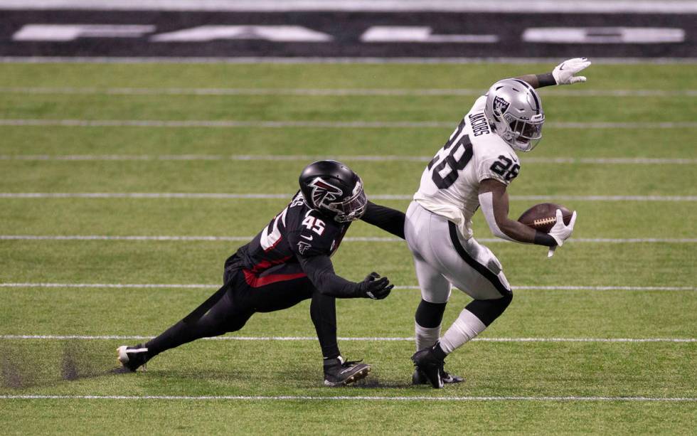 Las Vegas Raiders running back Josh Jacobs (28) spins free from Atlanta Falcons linebacker Deio ...