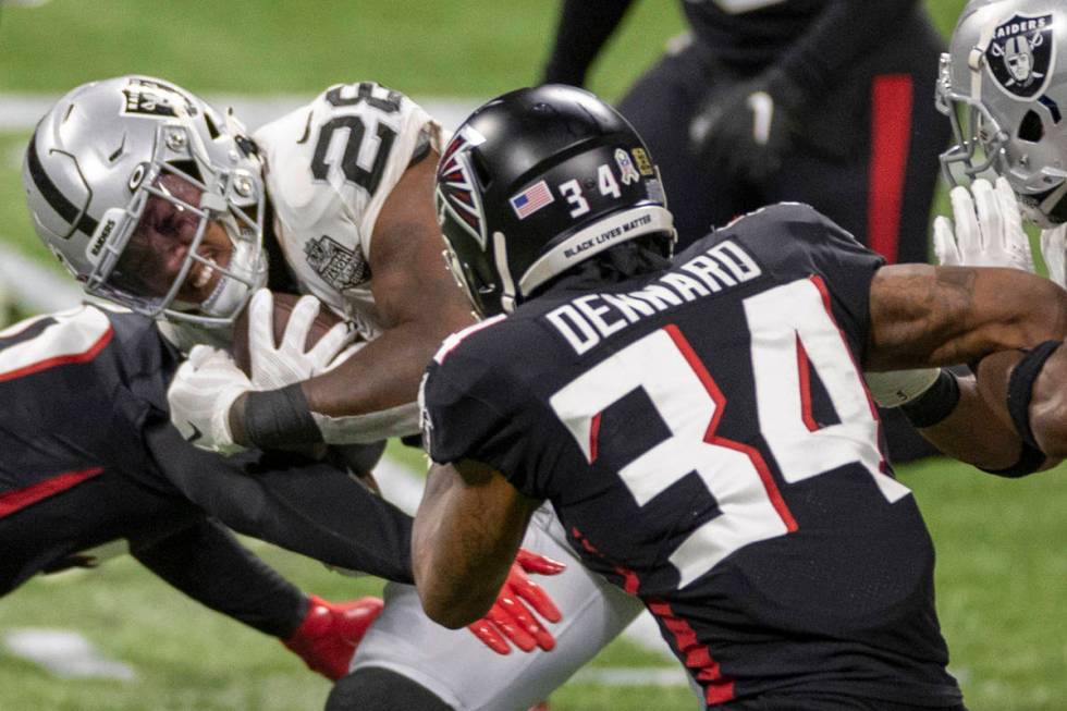 Las Vegas Raiders running back Josh Jacobs (28) is tackled by Atlanta Falcons cornerback Darque ...