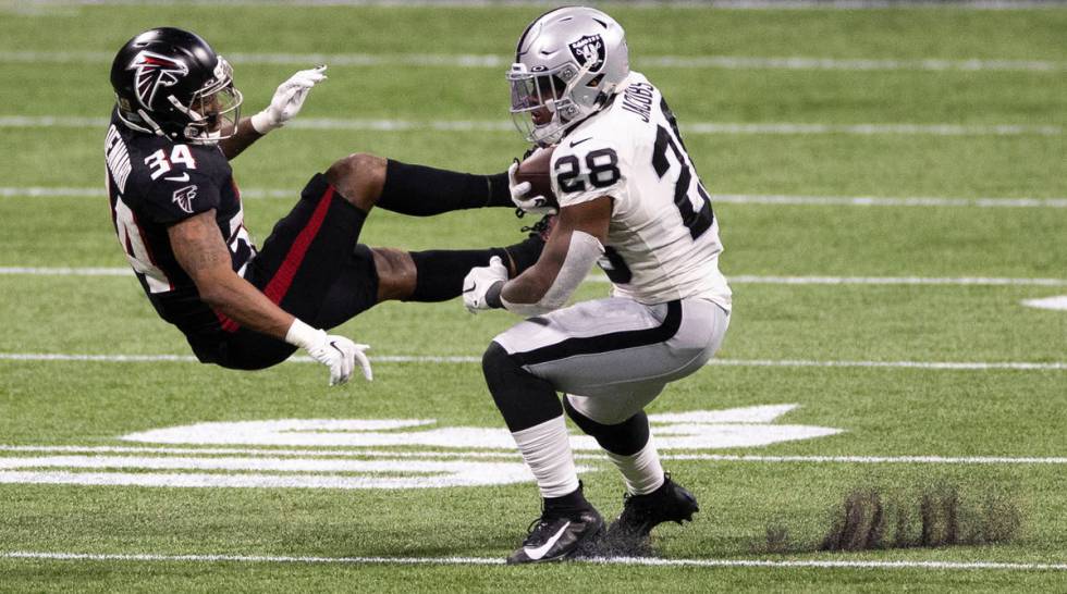 Las Vegas Raiders running back Josh Jacobs (28) breaks free from Atlanta Falcons cornerback Dar ...