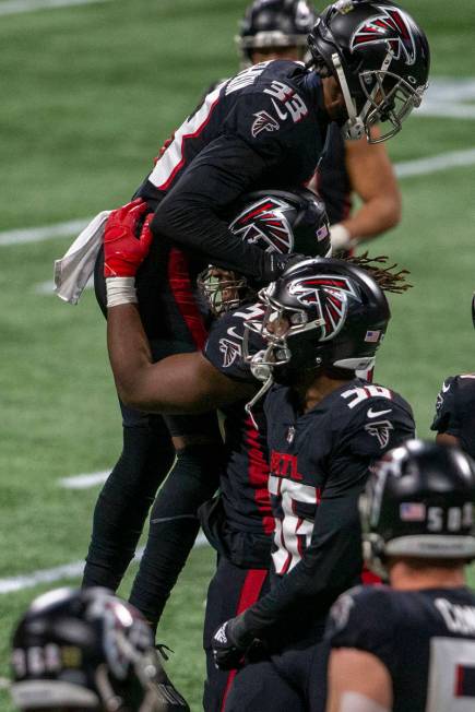 Atlanta Falcons cornerback Blidi Wreh-Wilson (33) celebrates with defensive end Steven Means (5 ...