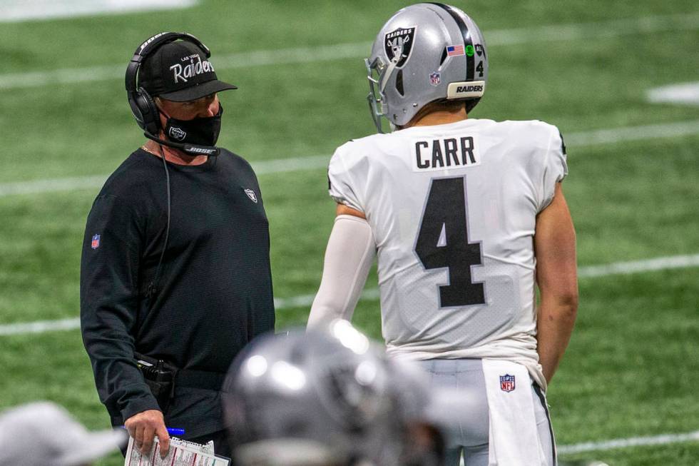 Las Vegas Raiders head coach Jon Gruden and quarterback Derek Carr (4) have a conversation duri ...