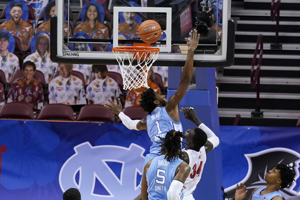 North Carolina guard Leaky Black (1) tries to block a shot by UNLV forward Cheikh Mbacke Diong ...