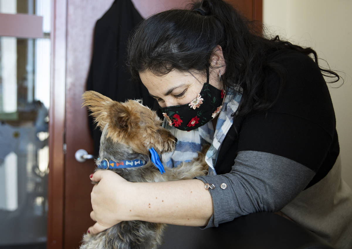 Marcella Jauregui, secretary for the District Attorney's office, cuddles with her dog Jack at t ...