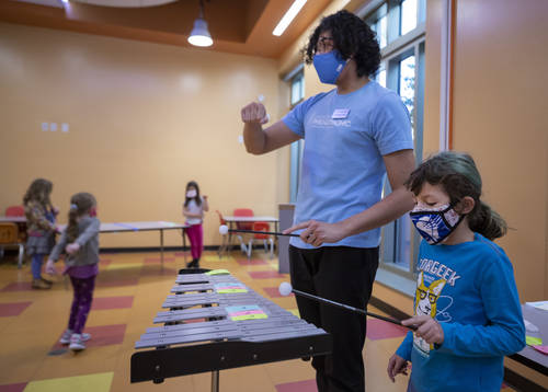 Las Vegas Philharmonic instructor Christopher Vivas, left, and Ryleigh Casper, 8, of Las Vegas, ...