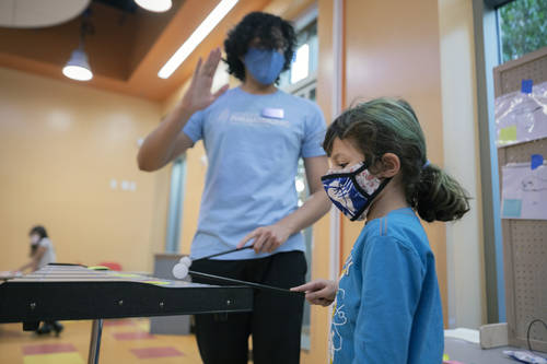 Las Vegas Philharmonic instructor Christopher Vivas, left, and Ryleigh Casper, 8, of Las Vegas, ...