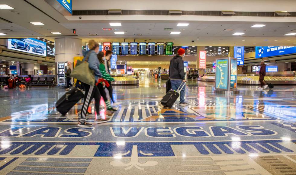 People come and go through baggage at Terminal 1 as holiday travel at McCarran International Ai ...