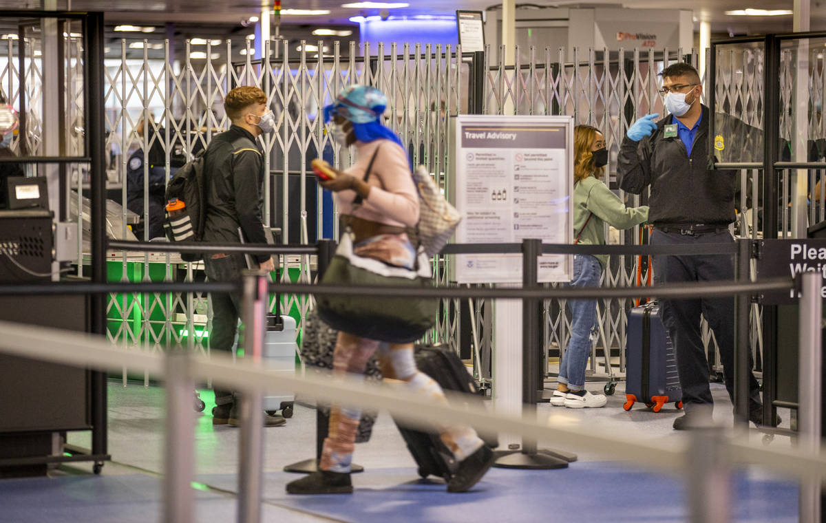 Travelers make their way through the TSA checkpoint at Terminal 1 during holiday travel at McCa ...