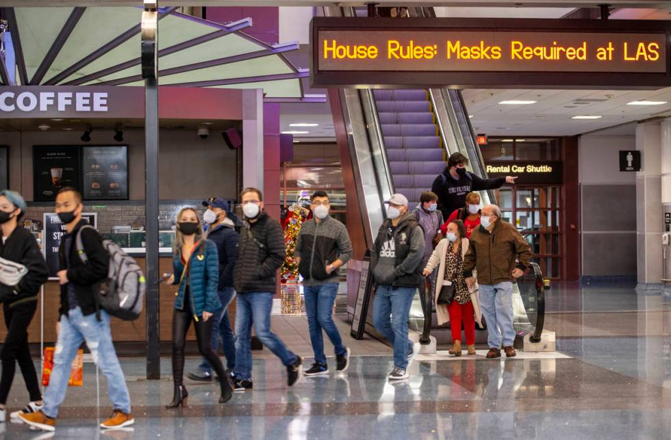 People arrive at baggage in Terminal 1 as holiday travel at McCarran International Airport cont ...