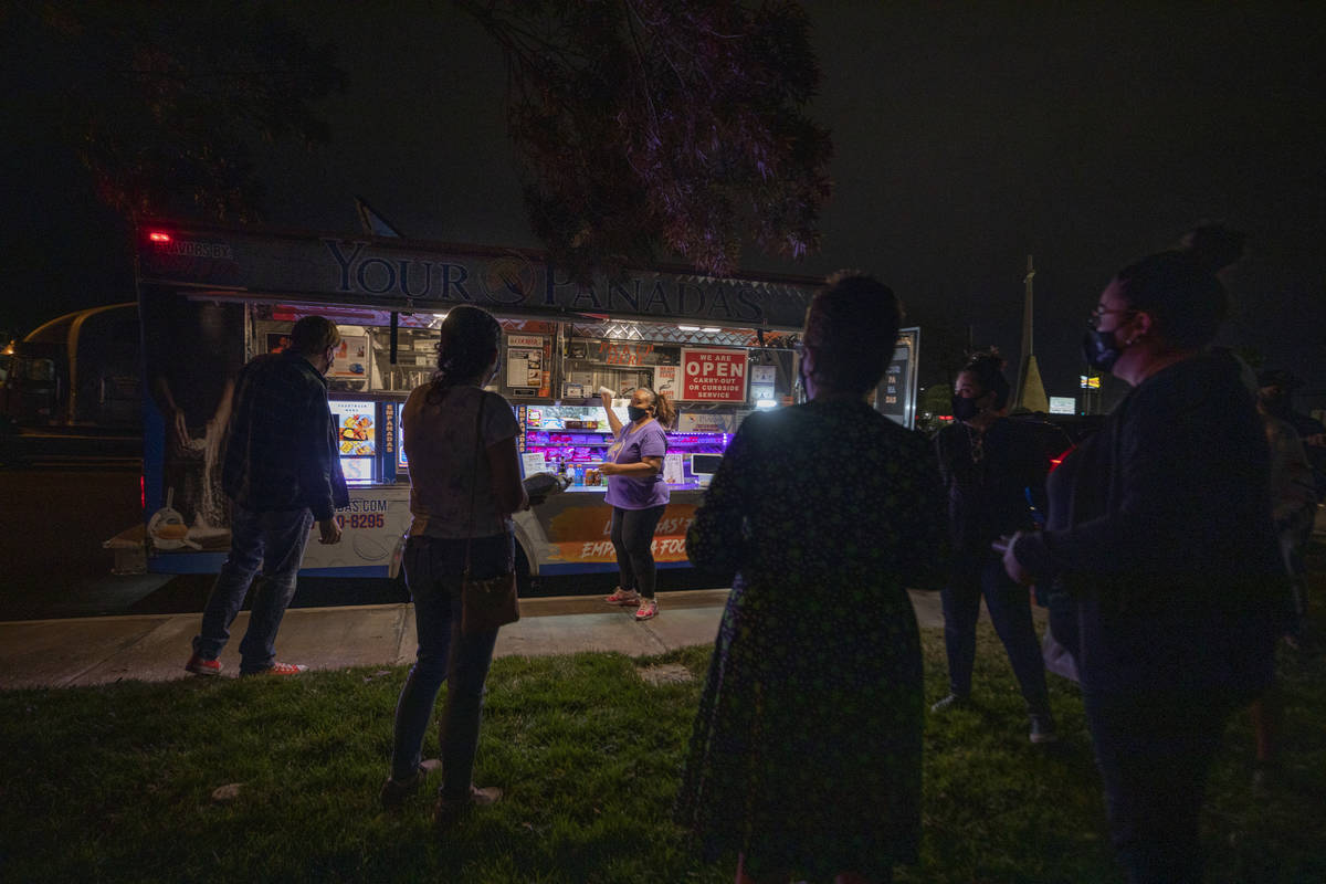 YourPanadas empanada truck owner Jinelle Batista, center, calls out an order to a socially dist ...