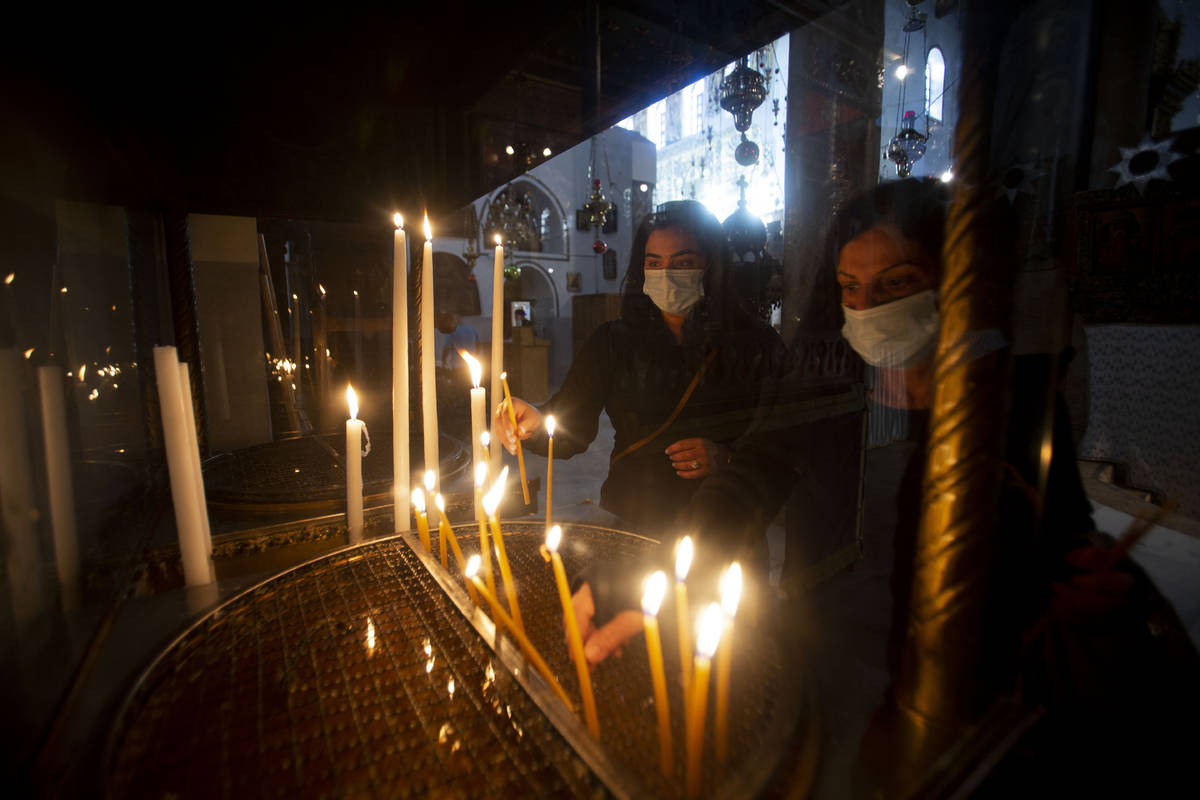Christian worshiper light candles in the Church of the Nativity, traditionally believed to be t ...