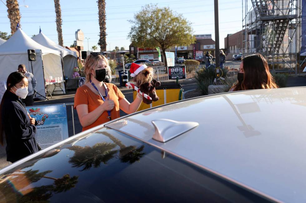 Volunteer Hanna Andersen thanks a driver who donated toys during the Chet Buchanan KLUC-FM toy ...