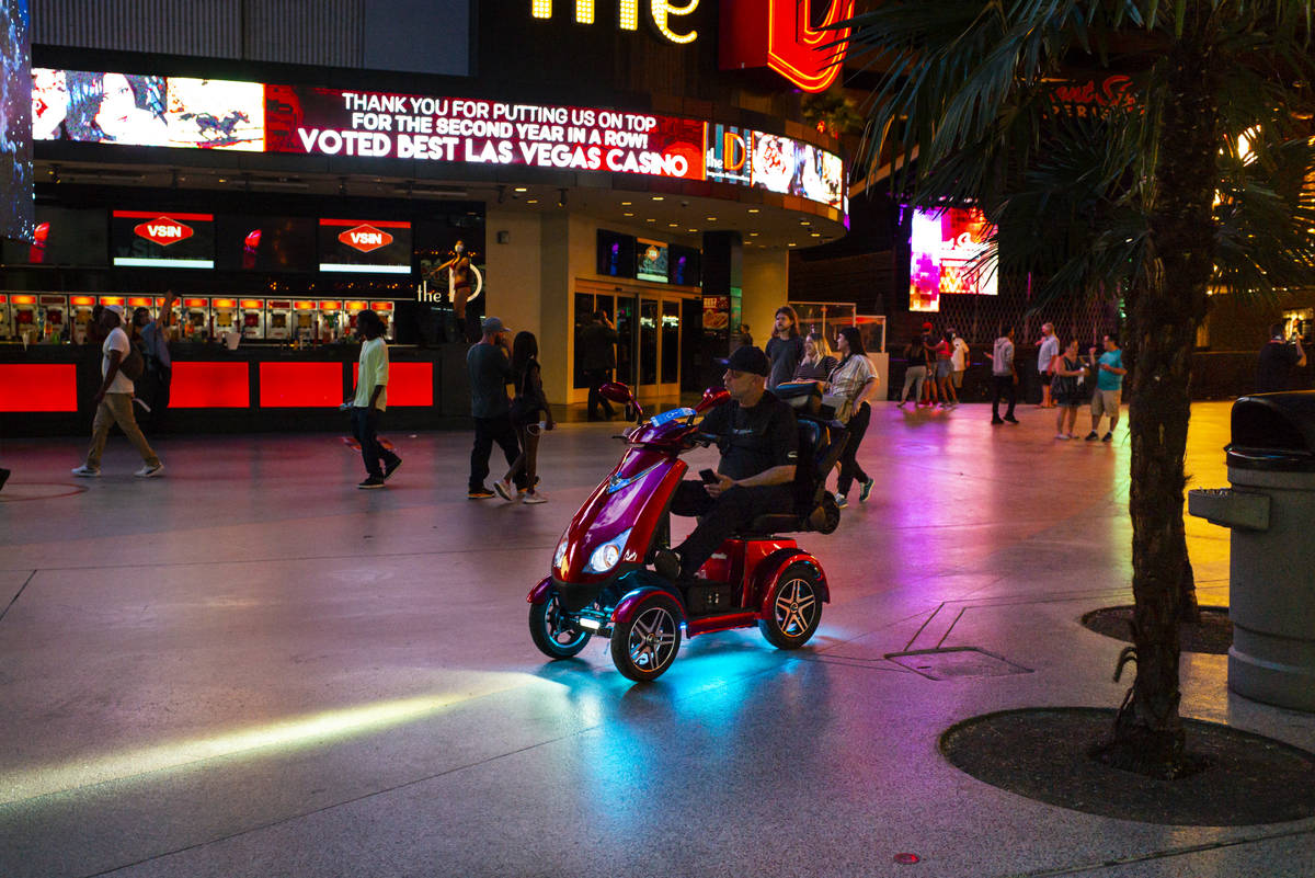 A man rides a scooter along the Fremont Street Experience as hotel-casinos reopen in downtown L ...