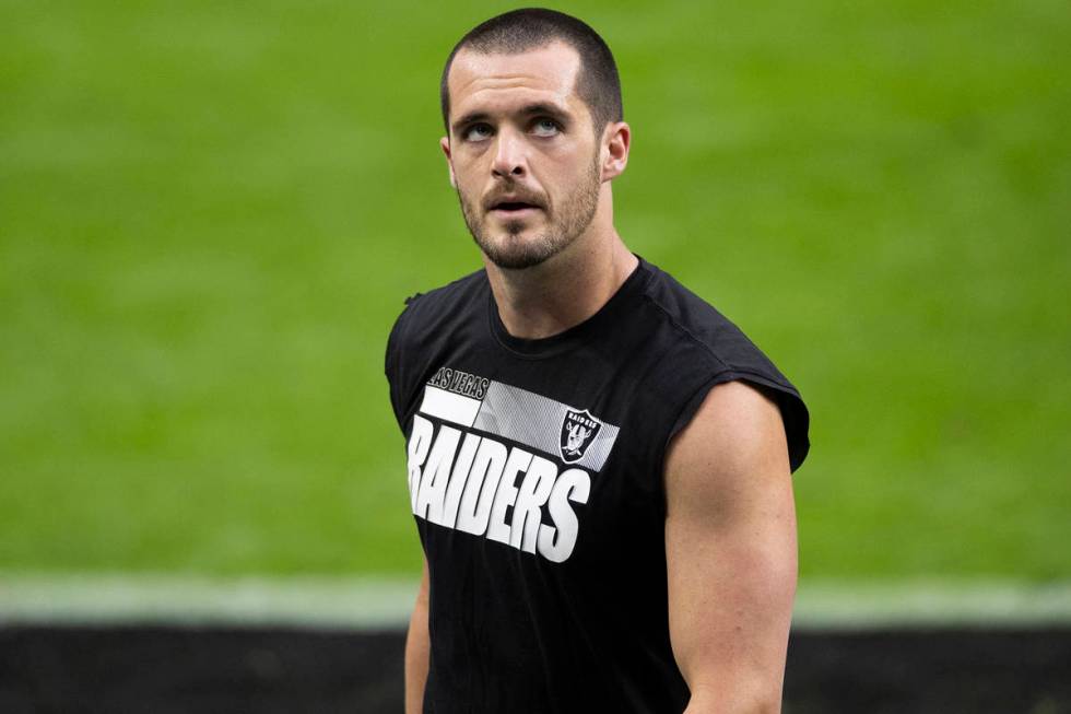 Las Vegas Raiders quarterback Derek Carr warms up before the start of an NFL football game agai ...