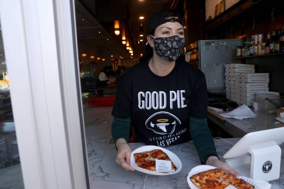 Rachel Guzman helps customers at the pizza slice window at Good Pie restaurant in the Arts Dist ...
