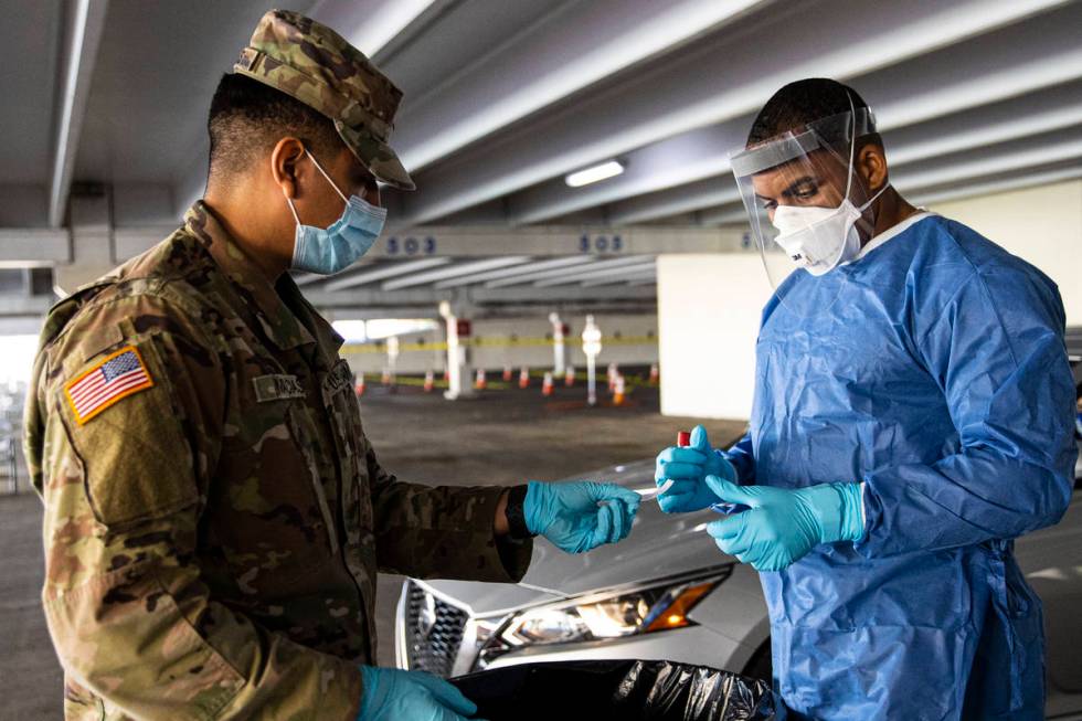 Nevada National Guard specialists Jonathan Macias, left, and Demetrie Barnett prepare to store ...