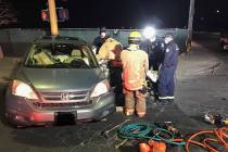 Las Vegas firefighters work to remove a motorist from a Honda sedan after a collision at Las Ve ...