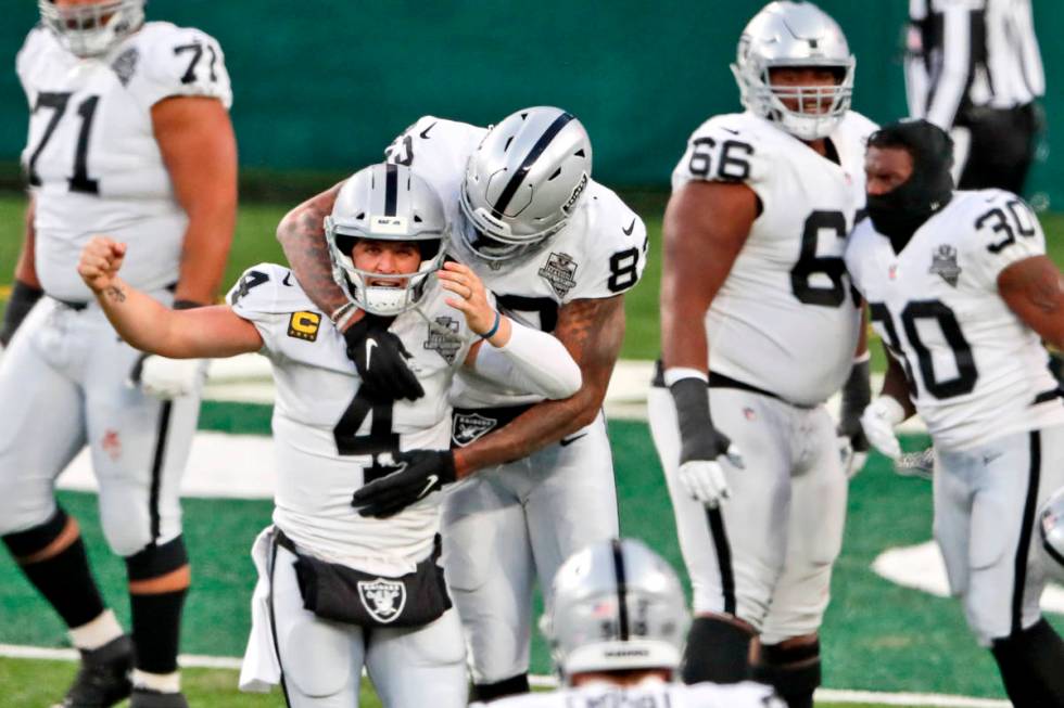 Las Vegas Raiders quarterback Derek Carr (4) celebrate after throwing a touchdown pass to Henry ...