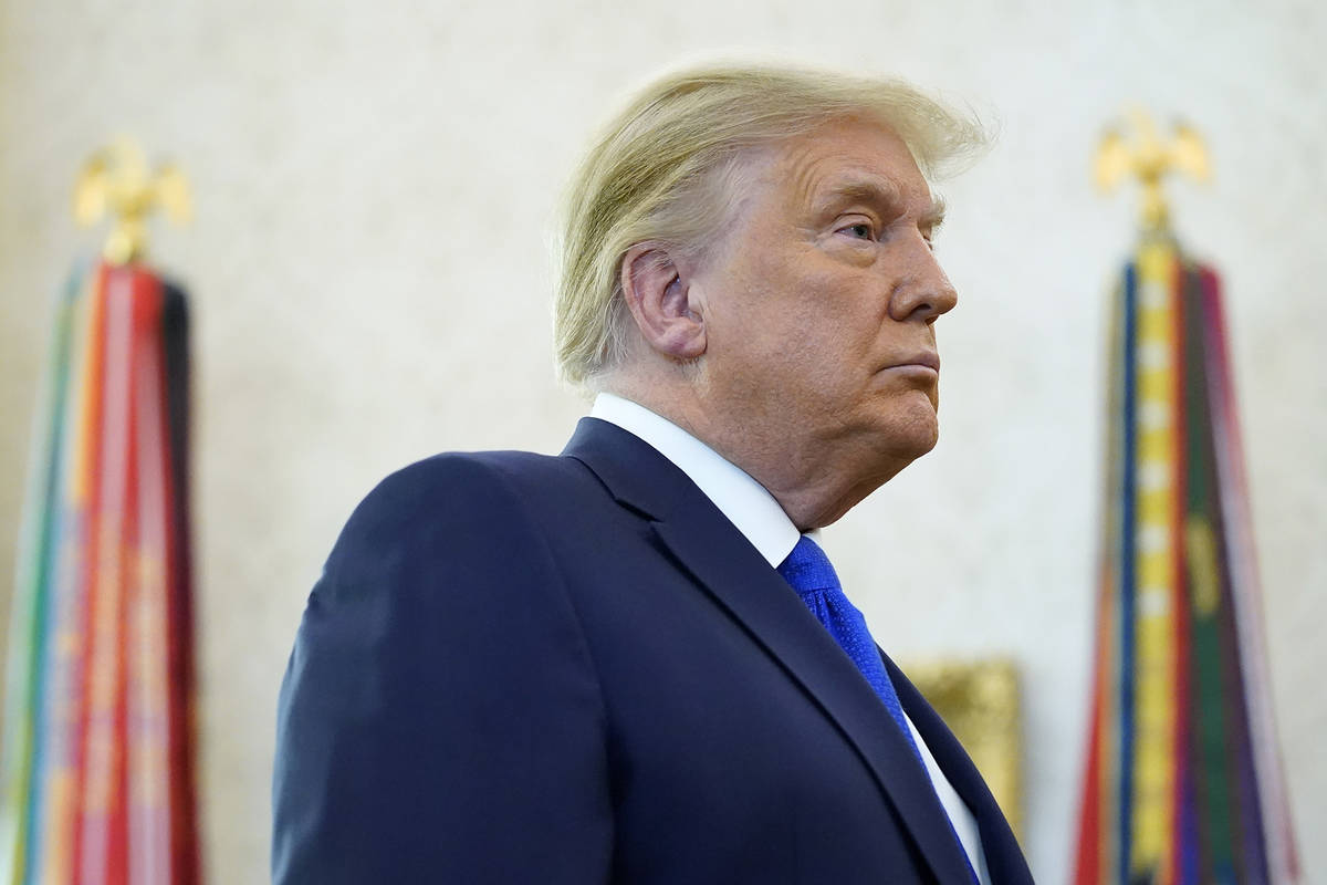 President Donald Trump listens to a reporter's question in the Oval Office of the White House, ...