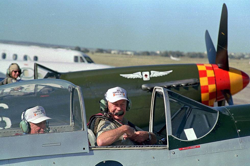 Chuck Yeager, right, straps himself into the cockpit of a vintage P-51 Mustang aircraft in prep ...