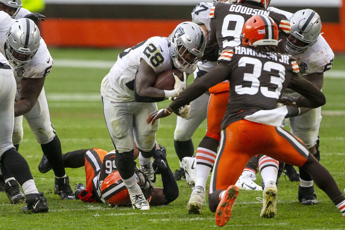 Las Vegas Raiders running back Josh Jacobs (28) sheds a tackle attempt by Cleveland Browns outs ...