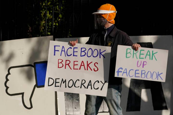 A demonstrator joins others outside of the home of Facebook CEO Mark Zuckerberg to protest what ...