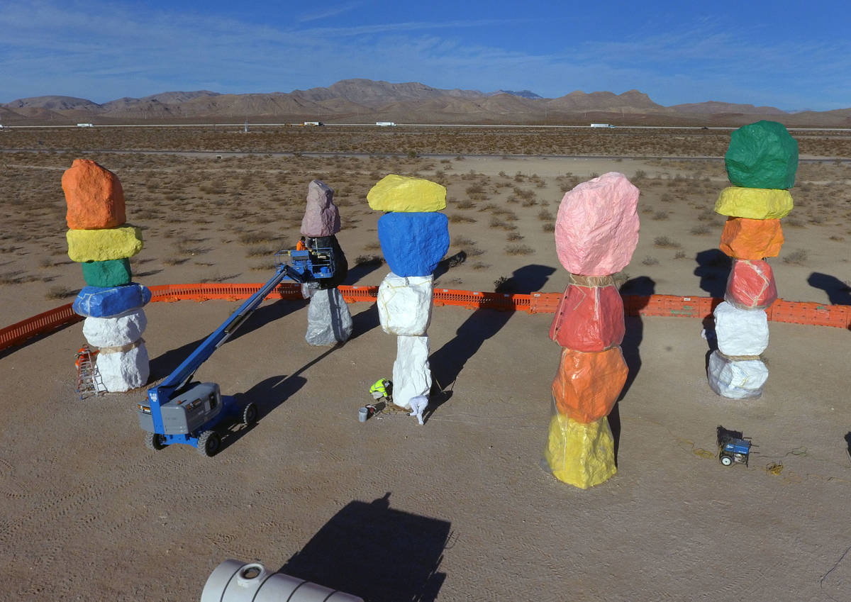 Workers from Vergith Contracting Co. begin prepping the Seven Magic Mountains totems for painti ...