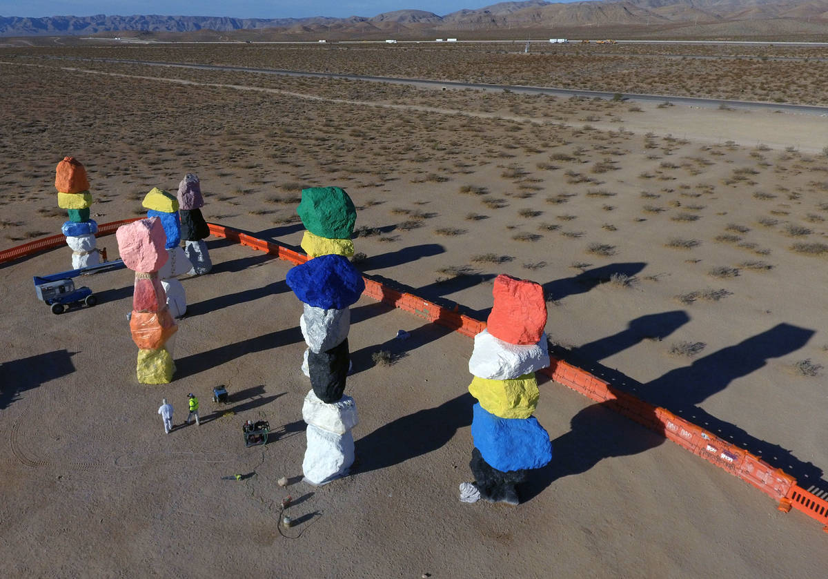 Workers from Vergith Contracting Co. begin prepping the Seven Magic Mountains totems for painti ...