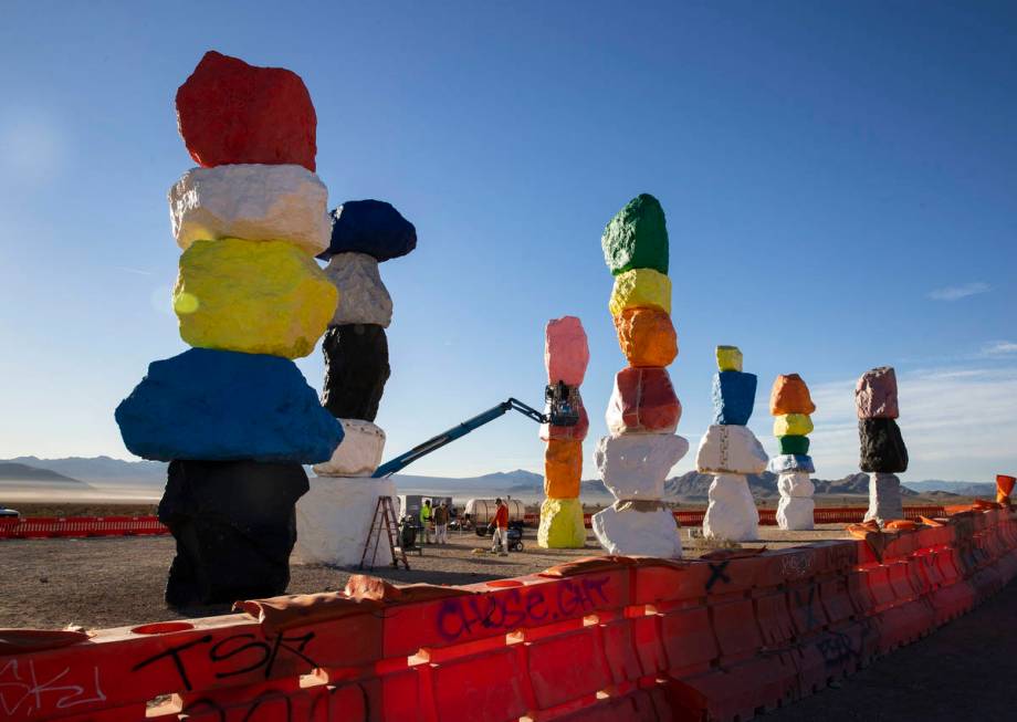 Workers from Vergith Contracting Co. begin prepping the Seven Magic Mountains totems for painti ...