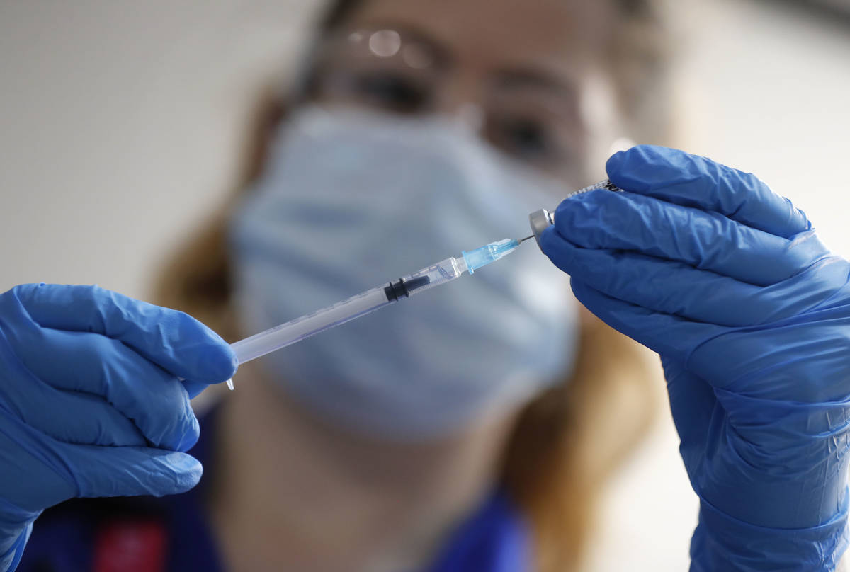 A nurse prepares a shot of the Pfizer-BioNTech COVID-19 vaccine at Guy's Hospital in London, Tu ...