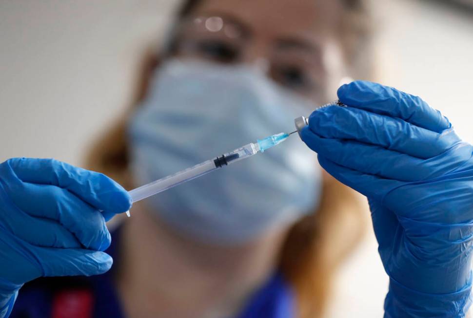 A nurse prepares a shot of the Pfizer-BioNTech COVID-19 vaccine at Guy's Hospital in London, Tu ...