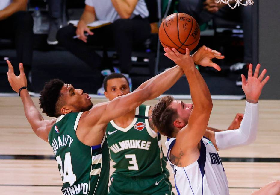 Milwaukee Bucks' Giannis Antetokounmpo (34) blocks a shot by Dallas Mavericks' Luka Doncic, rig ...