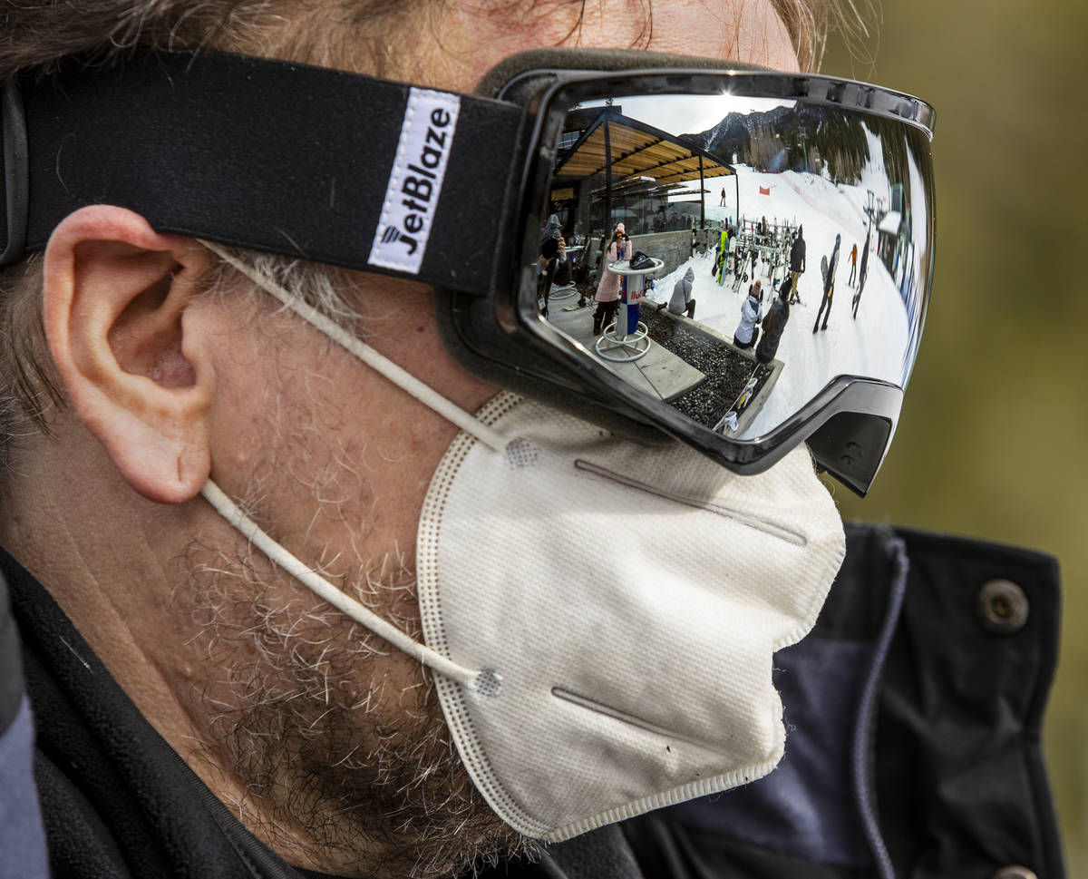 People are reflected in the snow goggles of Nik White of Las Vegas after his run near the lodge ...