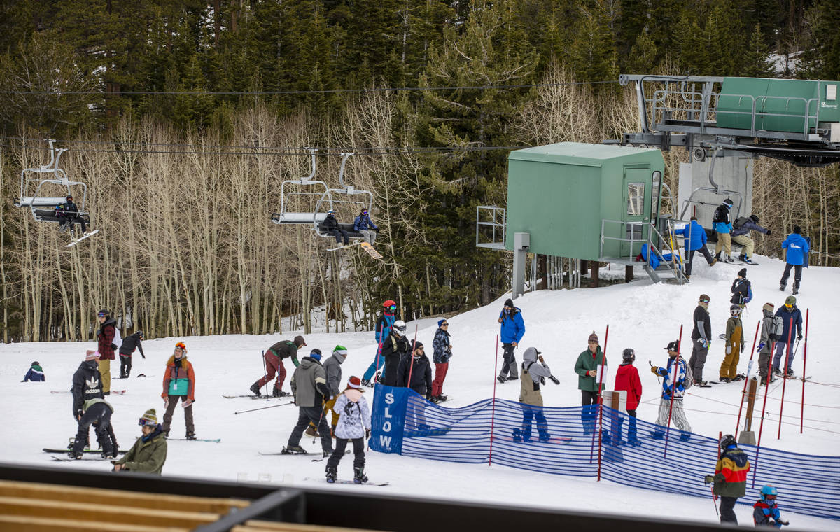 People move about the bottom of a run near the lift during opening day of skiing and snowboardi ...