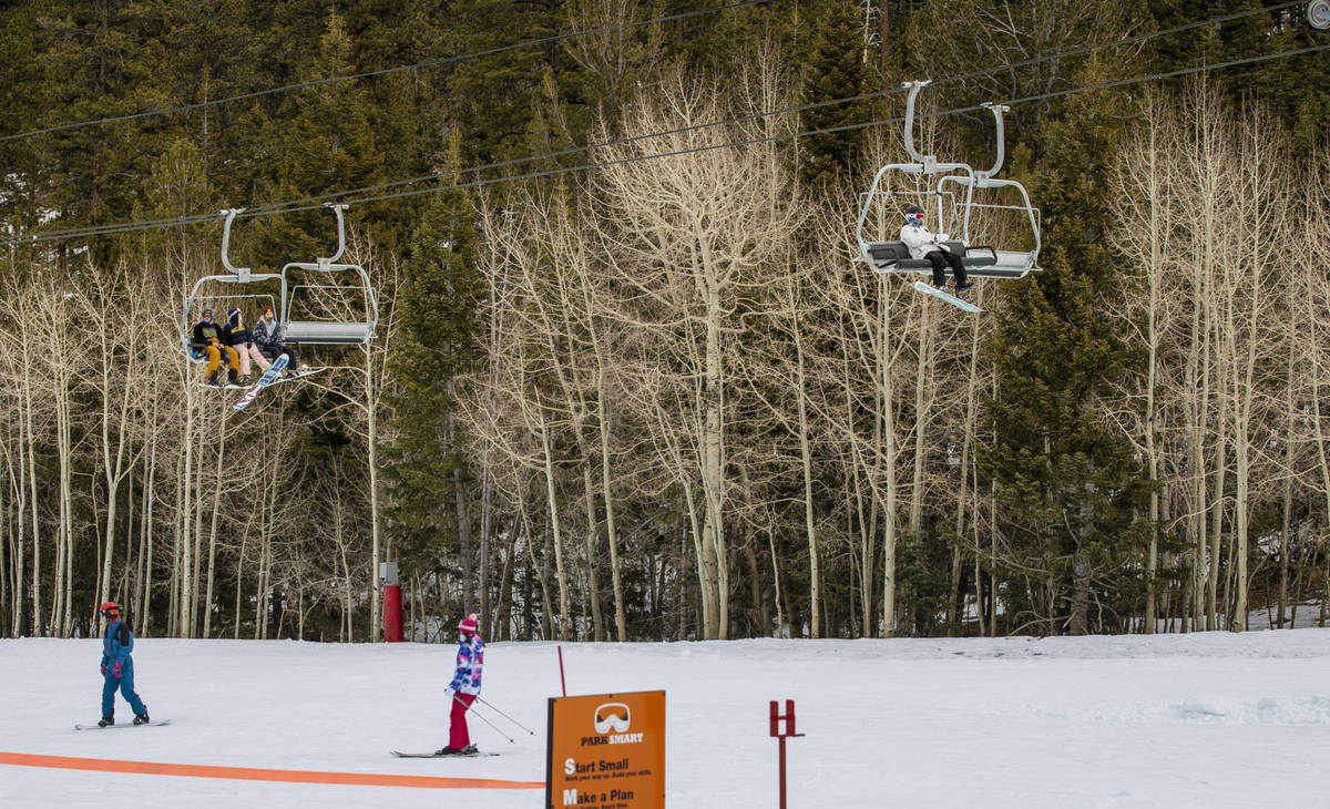 Snowboarders ride a lift during opening day of skiing and snowboarding at Lee Canyon atop Mount ...