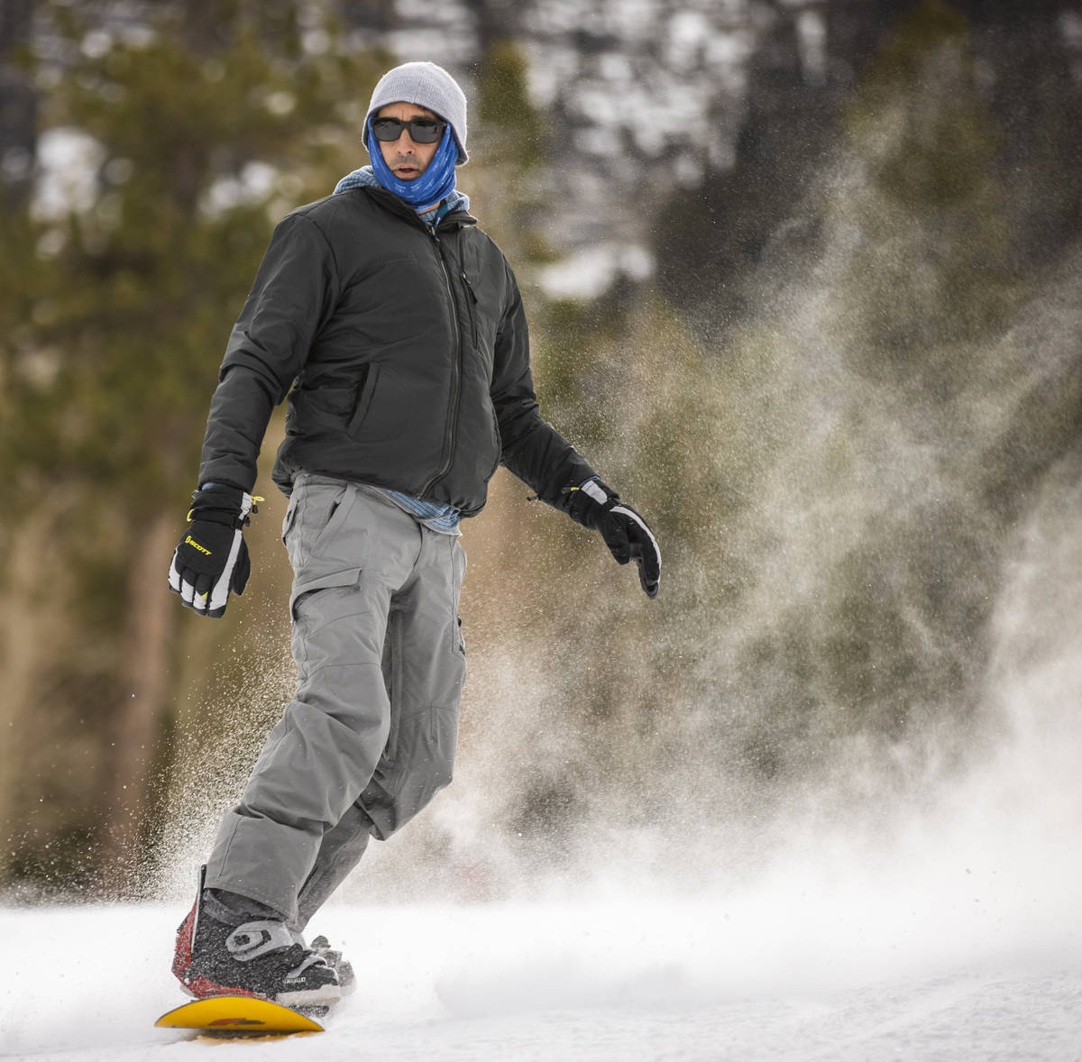 A snowboarder glides down the run near the lodge during opening day of skiing and snowboarding ...