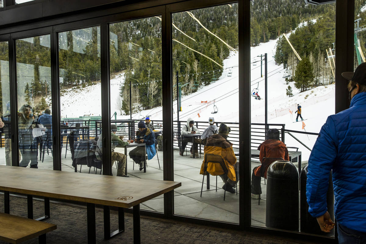 People gather in the outdoor seating at the lodge during opening day of skiing and snowboarding ...