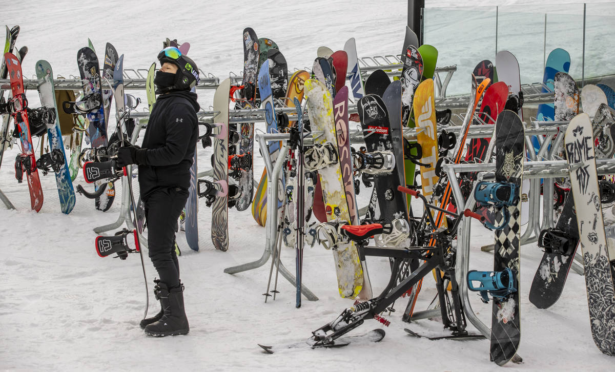 Skis and snowboards stack up in a rack near the lodge during opening day of skiing and snowboar ...