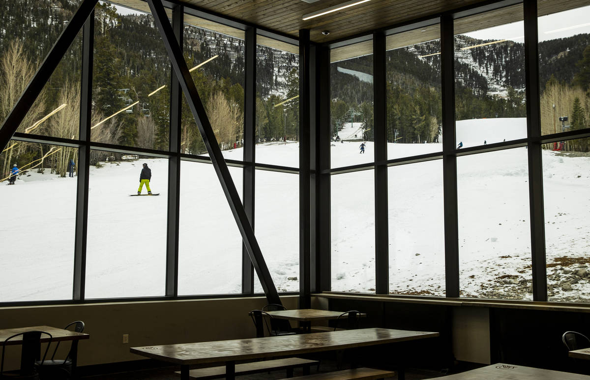 A snowboarder glides past the lodge during opening day of skiing and snowboarding at Lee Canyon ...