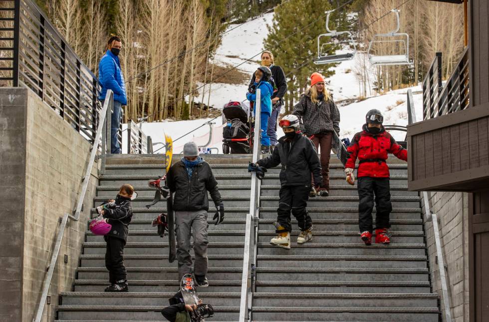 People carefully navigate the stairs leading from the lodge during opening day of skiing and sn ...