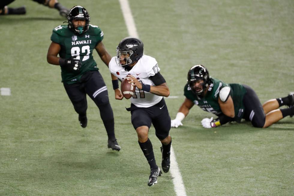 UNLV quarterback Doug Brumfield (17) runs away from the Hawaii rushers, including Djuan Matthew ...