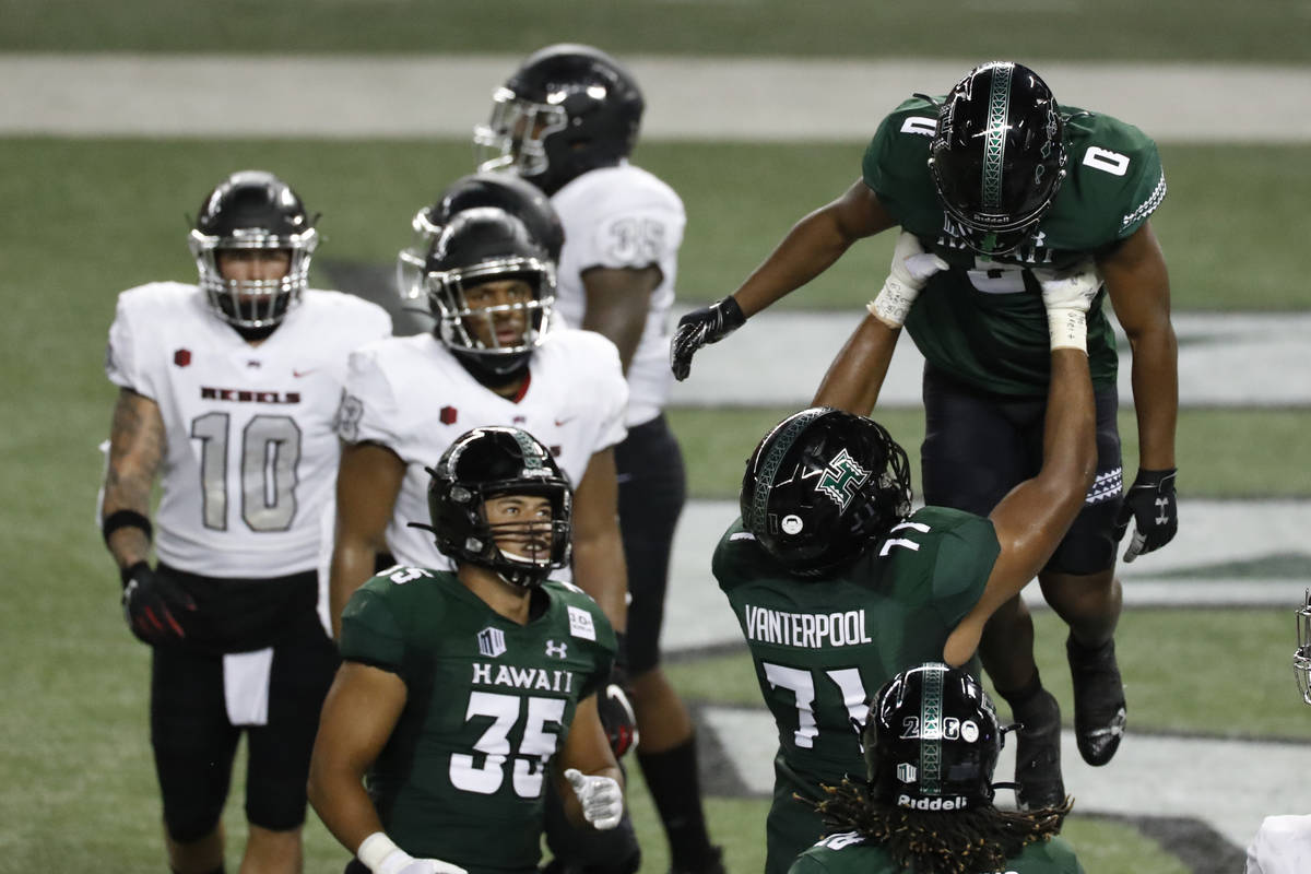 Hawaii running back Dae Dae Hunter (0) is lifted by offensive lineman Micah Vanterpool (71) aft ...