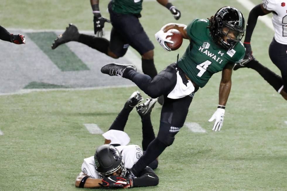 UNLV defensive back Bryce Jackson (24) trips Hawaii running back Miles Reed (4) during the firs ...