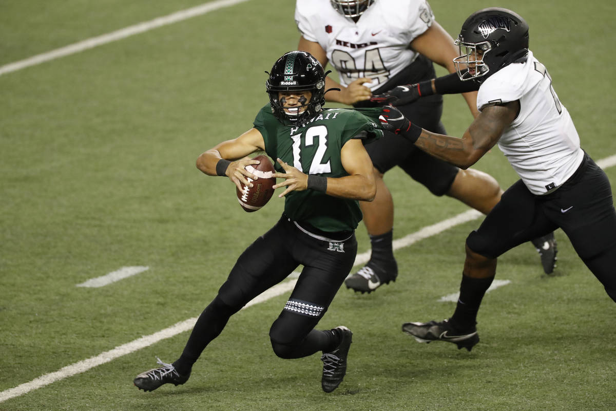 UNLV defensive lineman Adam Plant Jr. (7) pulls down Hawaii quarterback Chevan Cordeiro (12) in ...