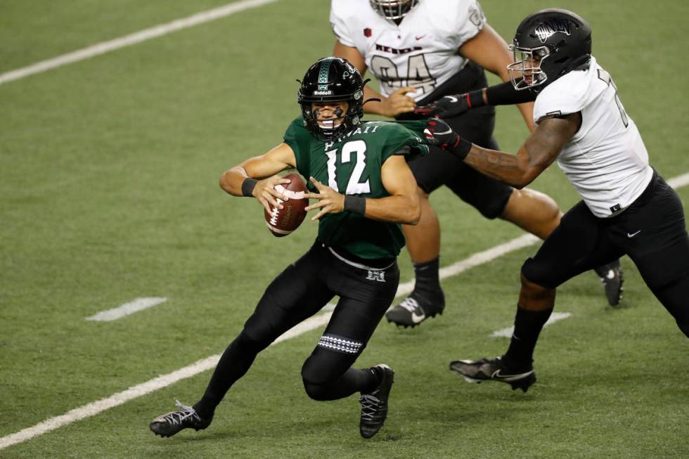 UNLV defensive lineman Adam Plant Jr. (7) pulls down Hawaii quarterback Chevan Cordeiro (12) in ...