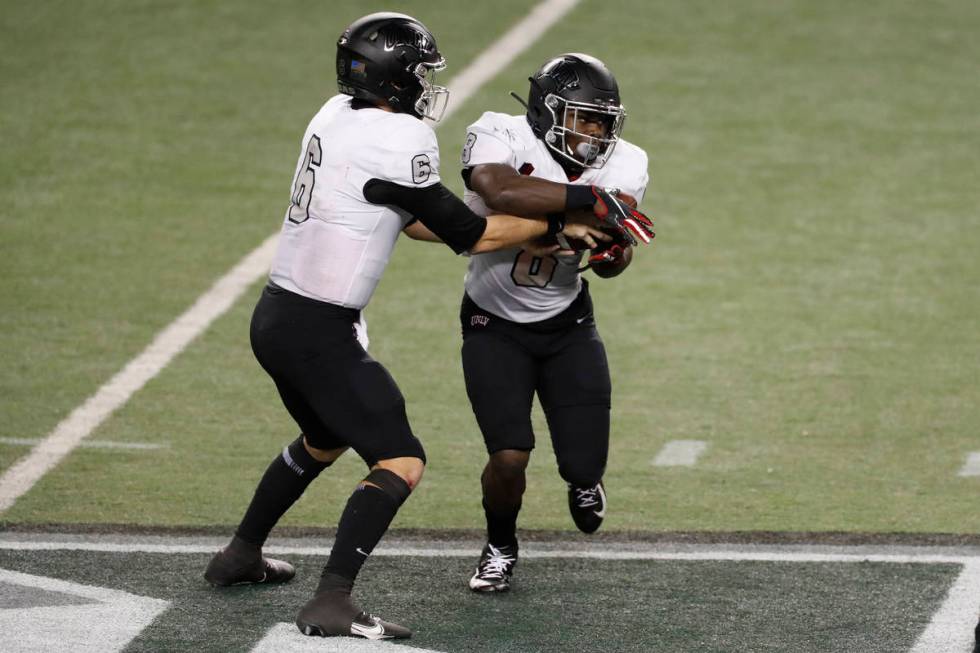 UNLV quarterback Max Gilliam (6) hands the ball to running back Charles Williams (8) in the sec ...