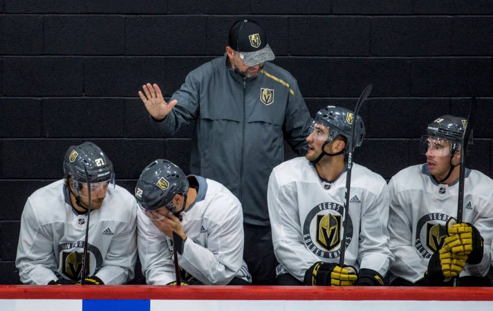 Vegas Golden Knights head coach Peter DeBoer, above, instructs center Nicolas Roy (10, below) a ...