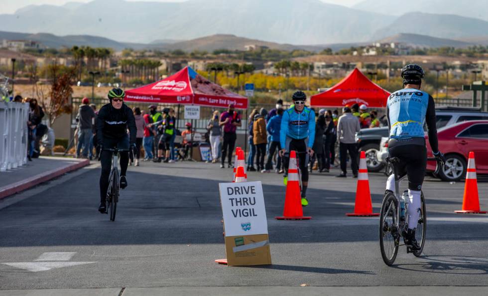 Cyclists stream about during a vigil honoring the lives of five Las Vegas cyclists who lost the ...